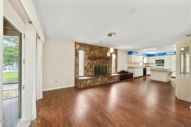 unfurnished living room featuring dark wood-style floors, baseboards, a fireplace, and visible vents