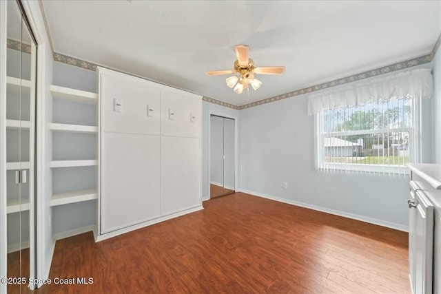 unfurnished bedroom featuring ceiling fan, baseboards, and wood finished floors