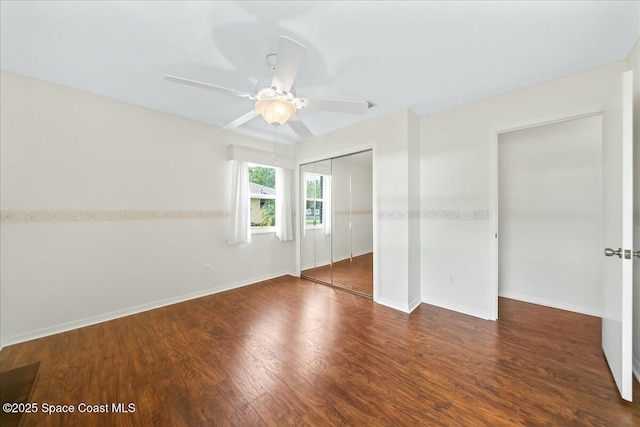 unfurnished bedroom featuring a closet, ceiling fan, baseboards, and wood finished floors