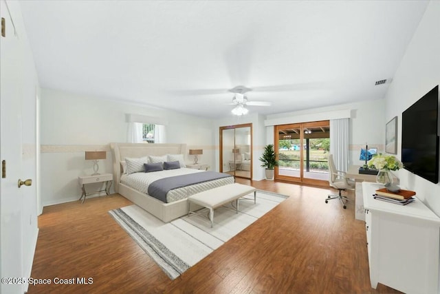 bedroom with access to outside, visible vents, ceiling fan, and wood finished floors