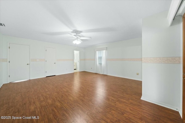 empty room with ceiling fan, wood finished floors, and visible vents