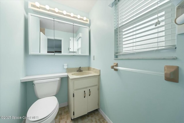 bathroom featuring baseboards, vanity, and toilet