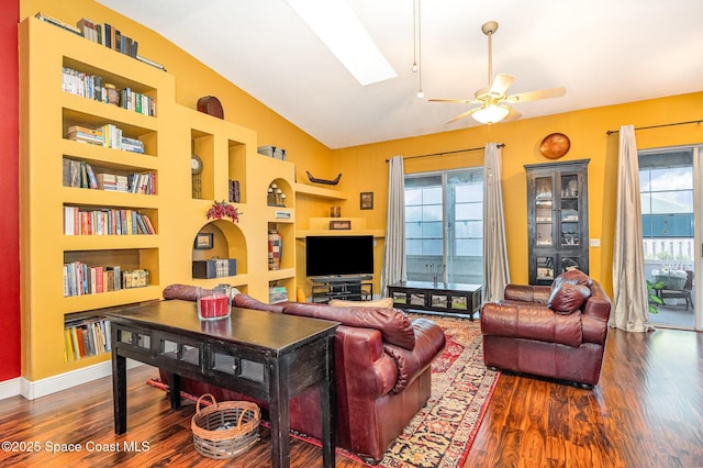 living area with vaulted ceiling, ceiling fan, wood finished floors, and built in features