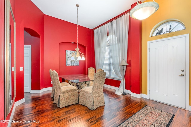 dining area featuring a chandelier, wood finished floors, and baseboards