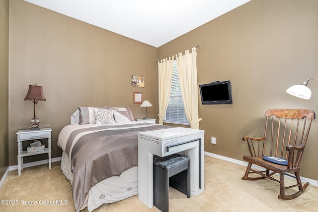 bedroom with light carpet, vaulted ceiling, and baseboards