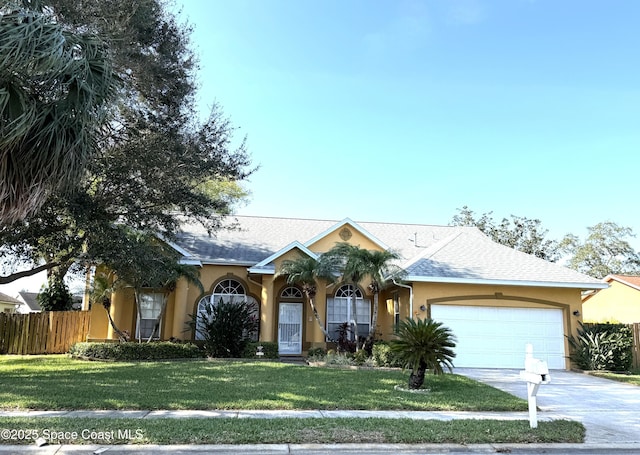 view of front facade featuring concrete driveway, stucco siding, an attached garage, fence, and a front yard