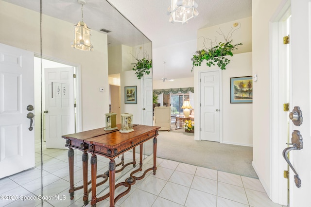 foyer with light colored carpet, visible vents, and light tile patterned floors