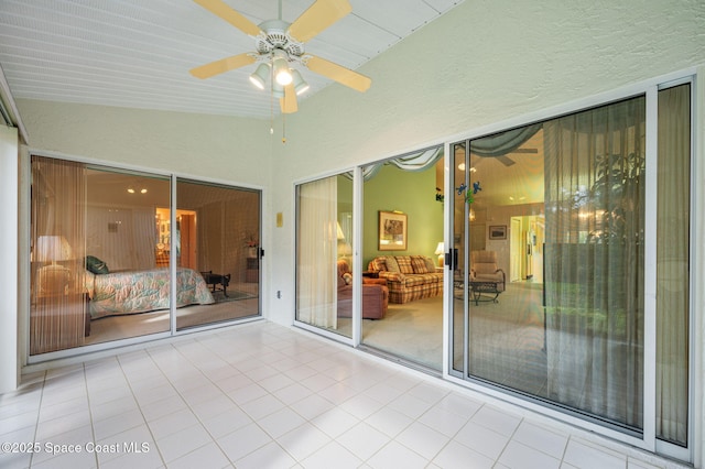 unfurnished sunroom featuring a ceiling fan and vaulted ceiling