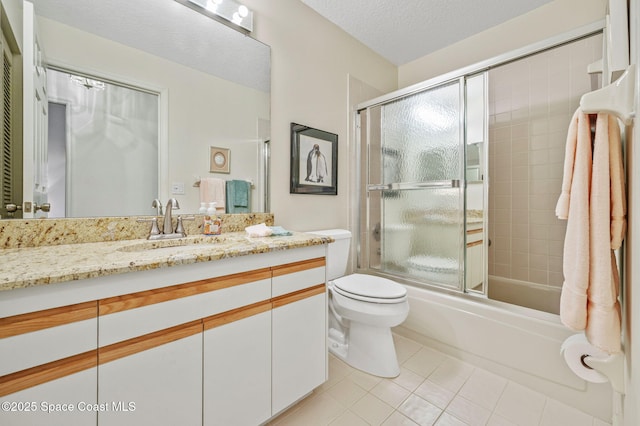 bathroom with toilet, tile patterned flooring, combined bath / shower with glass door, a textured ceiling, and vanity