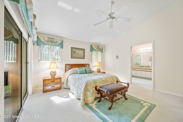 bedroom featuring carpet floors, lofted ceiling, baseboards, and ensuite bathroom