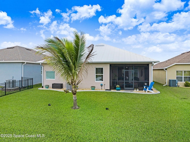 rear view of property with central AC, fence, a sunroom, a yard, and stucco siding