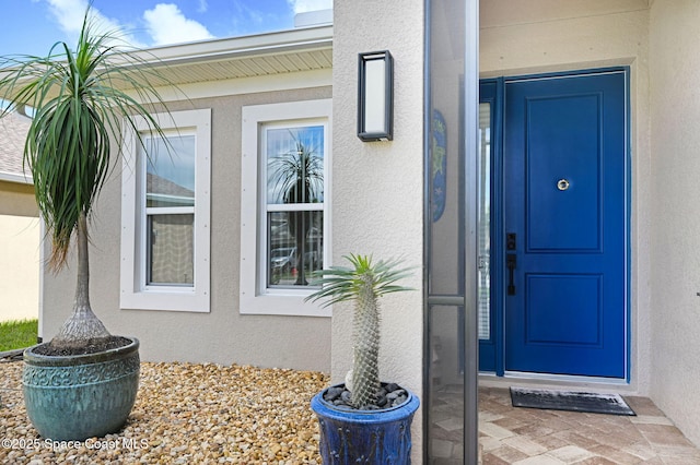 view of exterior entry with stucco siding