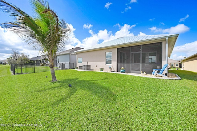 back of house featuring a sunroom, fence, cooling unit, a yard, and stucco siding