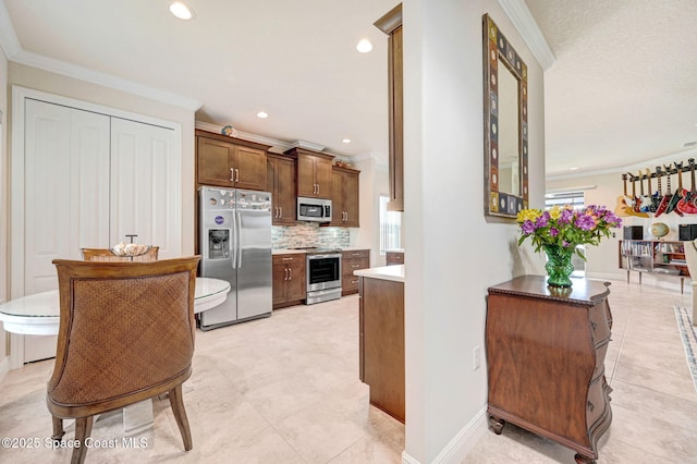 kitchen featuring recessed lighting, baseboards, appliances with stainless steel finishes, decorative backsplash, and crown molding