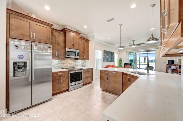 kitchen featuring crown molding, tasteful backsplash, visible vents, appliances with stainless steel finishes, and a sink