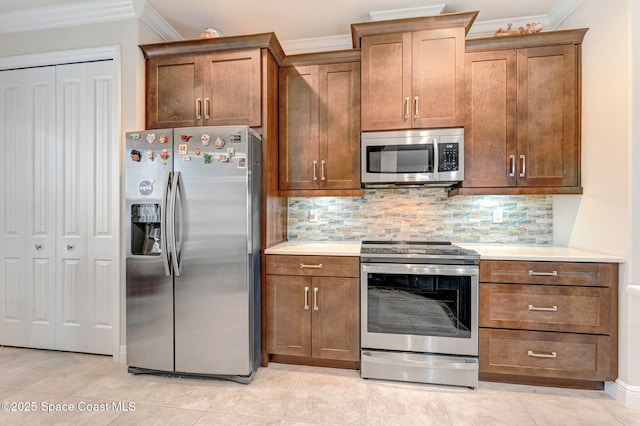 kitchen featuring stainless steel appliances, ornamental molding, backsplash, and light countertops