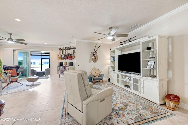 living room featuring ornamental molding, visible vents, ceiling fan, and light tile patterned floors