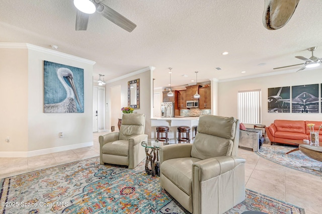 living area featuring ceiling fan, ornamental molding, a textured ceiling, and light tile patterned flooring