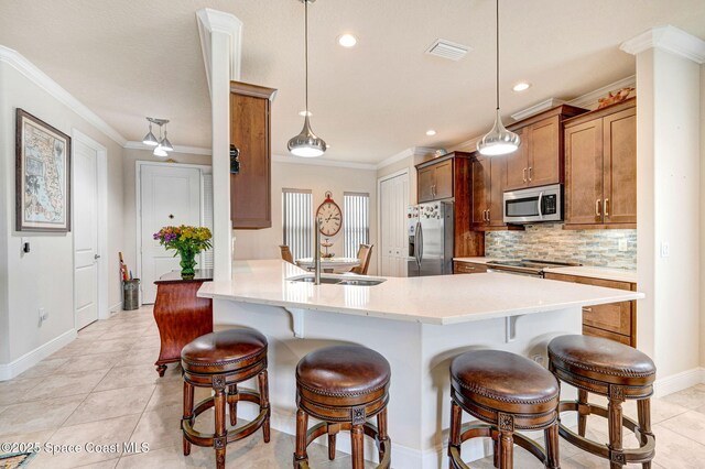 kitchen with stainless steel appliances, a breakfast bar, ornamental molding, and tasteful backsplash