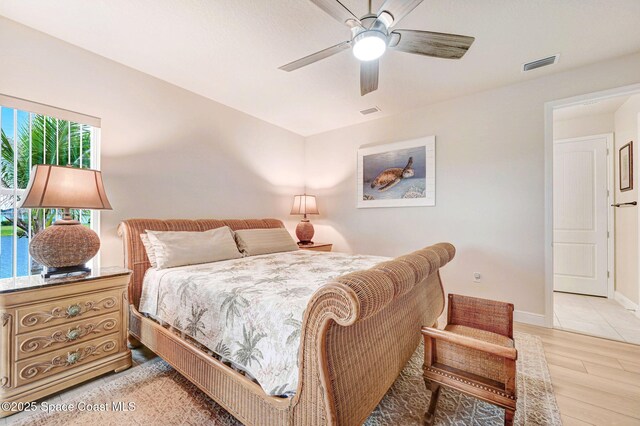 bedroom with baseboards, ceiling fan, visible vents, and light wood-style floors