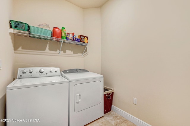 laundry room with baseboards, laundry area, light tile patterned floors, and washer and dryer