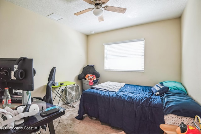 carpeted bedroom featuring a textured ceiling and a ceiling fan