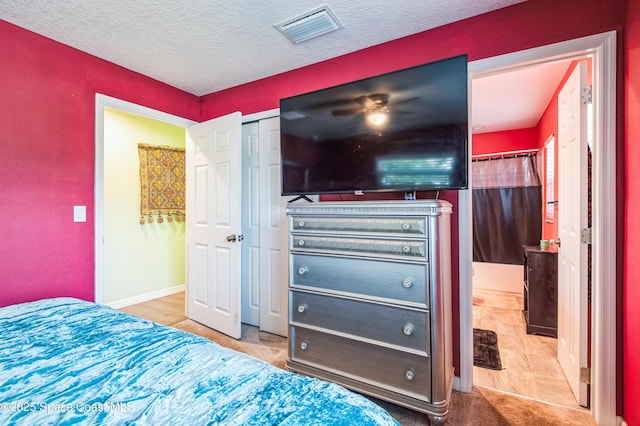 bedroom with baseboards, visible vents, and a textured ceiling