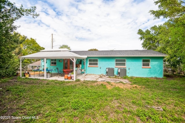 rear view of house featuring central air condition unit, a patio area, and a yard