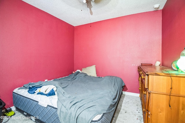 carpeted bedroom with ceiling fan, a textured ceiling, and baseboards