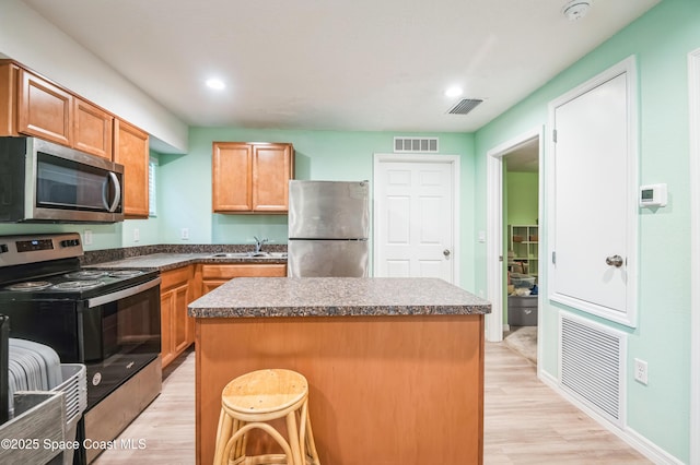 kitchen with stainless steel appliances, a sink, and visible vents