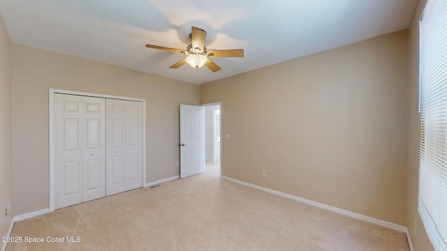 unfurnished bedroom with light carpet, visible vents, baseboards, a ceiling fan, and a closet