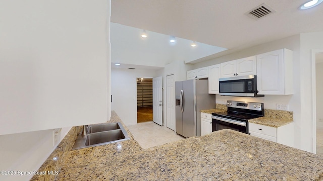 kitchen featuring visible vents, white cabinets, appliances with stainless steel finishes, light stone counters, and a sink