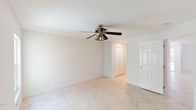 unfurnished room with ceiling fan and baseboards