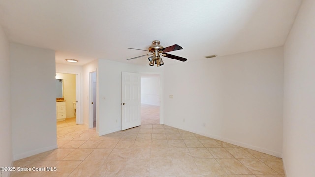 unfurnished room with ceiling fan, visible vents, and baseboards