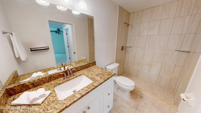 full bathroom with vanity, tiled shower, tile patterned flooring, and toilet