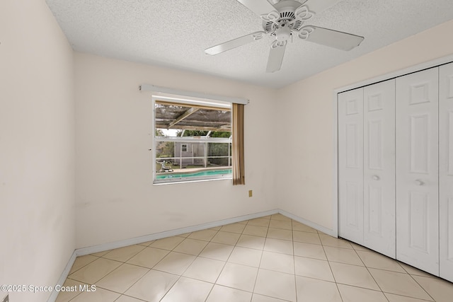 unfurnished bedroom with a ceiling fan, a textured ceiling, baseboards, and a closet