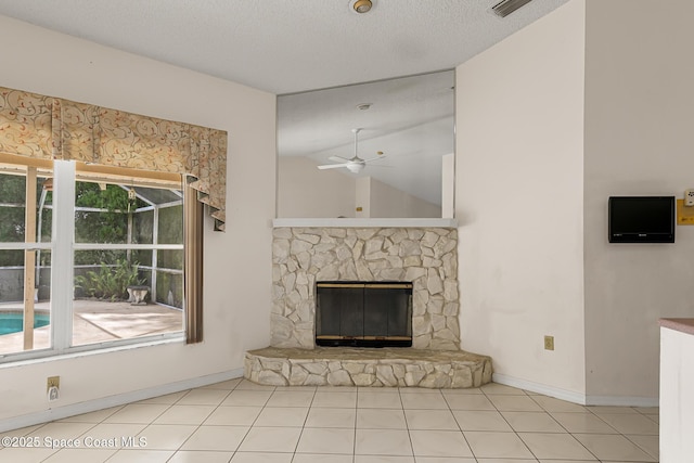 unfurnished living room featuring ceiling fan, a textured ceiling, tile patterned flooring, a fireplace, and vaulted ceiling