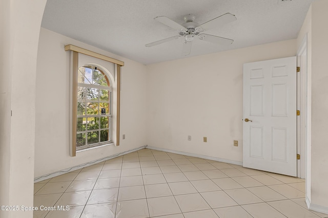 empty room featuring ceiling fan and baseboards