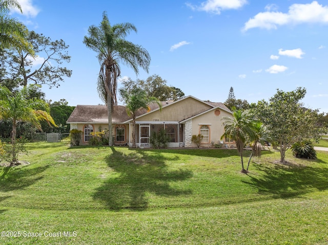 view of front of home with fence, a front lawn, and stucco siding