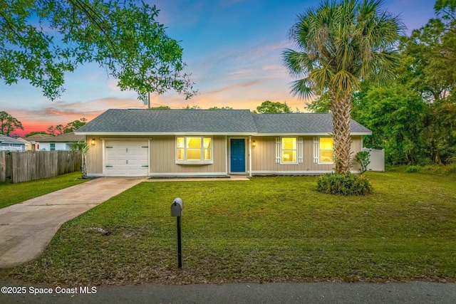 ranch-style home featuring a yard, driveway, a garage, and fence