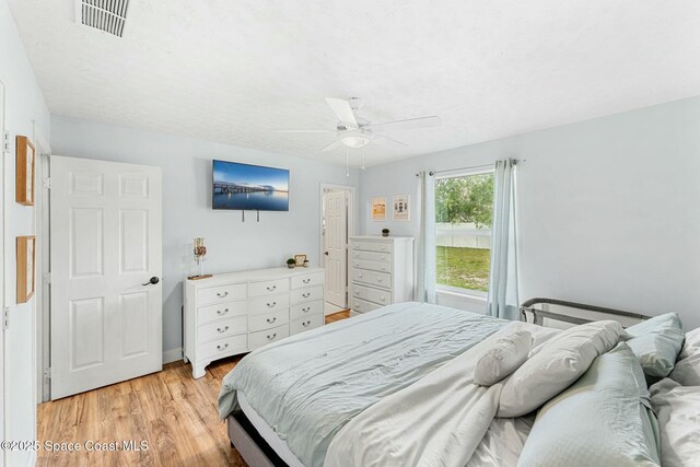 bedroom featuring a ceiling fan, visible vents, and light wood-style flooring