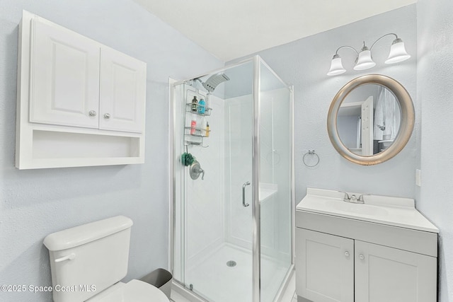 full bathroom featuring a shower stall, toilet, and vanity