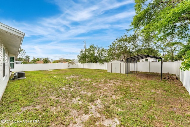 view of yard with a detached carport, central AC, a fenced backyard, and a shed