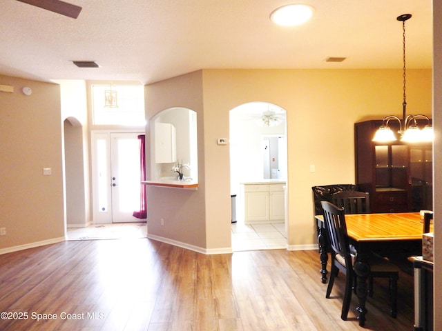 4590 Brantford Ct, Rockledge, FL 32955 - dining room with arched walkways, wood finished floors, a chandelier, and baseboards