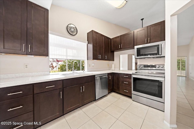 kitchen with dark brown cabinets, appliances with stainless steel finishes, light countertops, and a sink