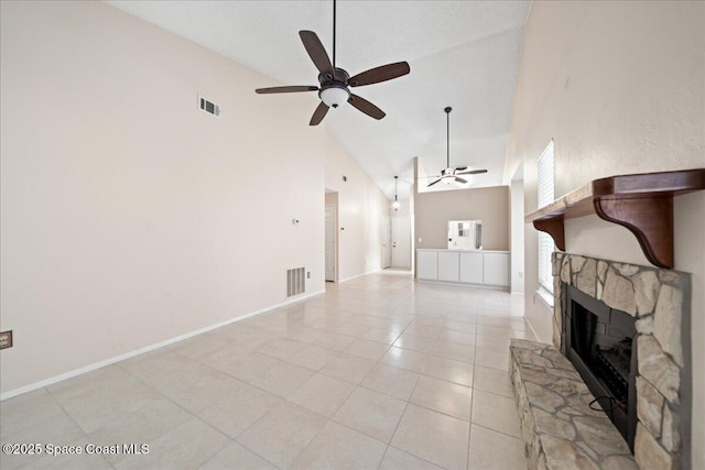 unfurnished living room featuring visible vents, ceiling fan, a stone fireplace, and light tile patterned flooring