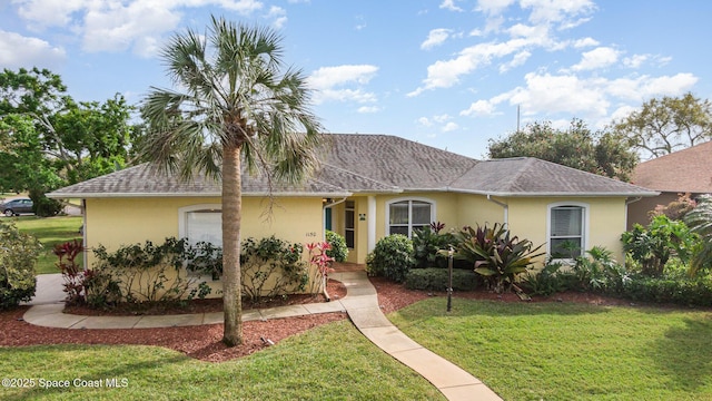 ranch-style home featuring a front lawn, a shingled roof, and stucco siding