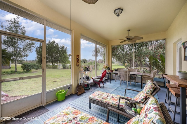 sunroom / solarium with plenty of natural light and ceiling fan