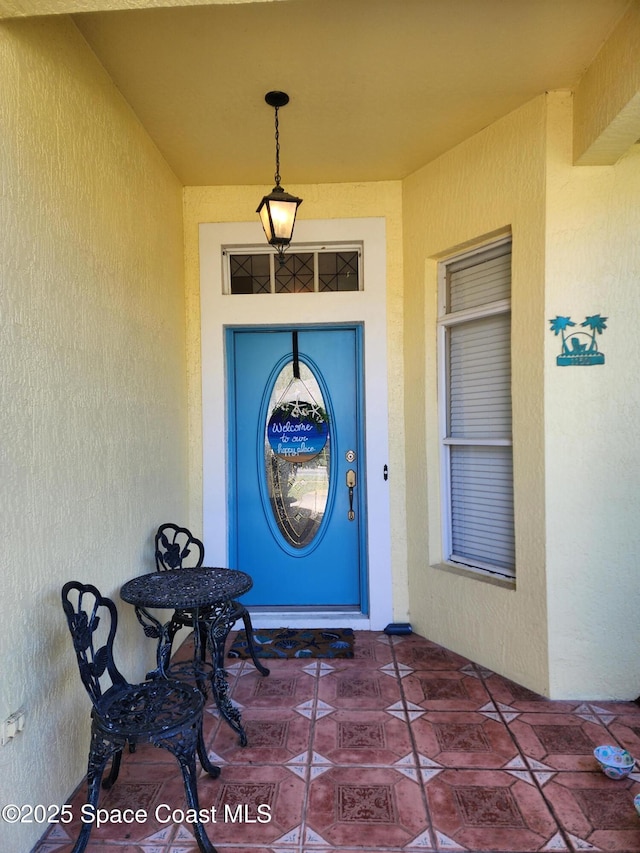 view of exterior entry with stucco siding