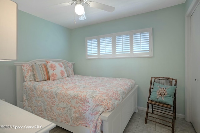 bedroom featuring tile patterned flooring, baseboards, a closet, and ceiling fan